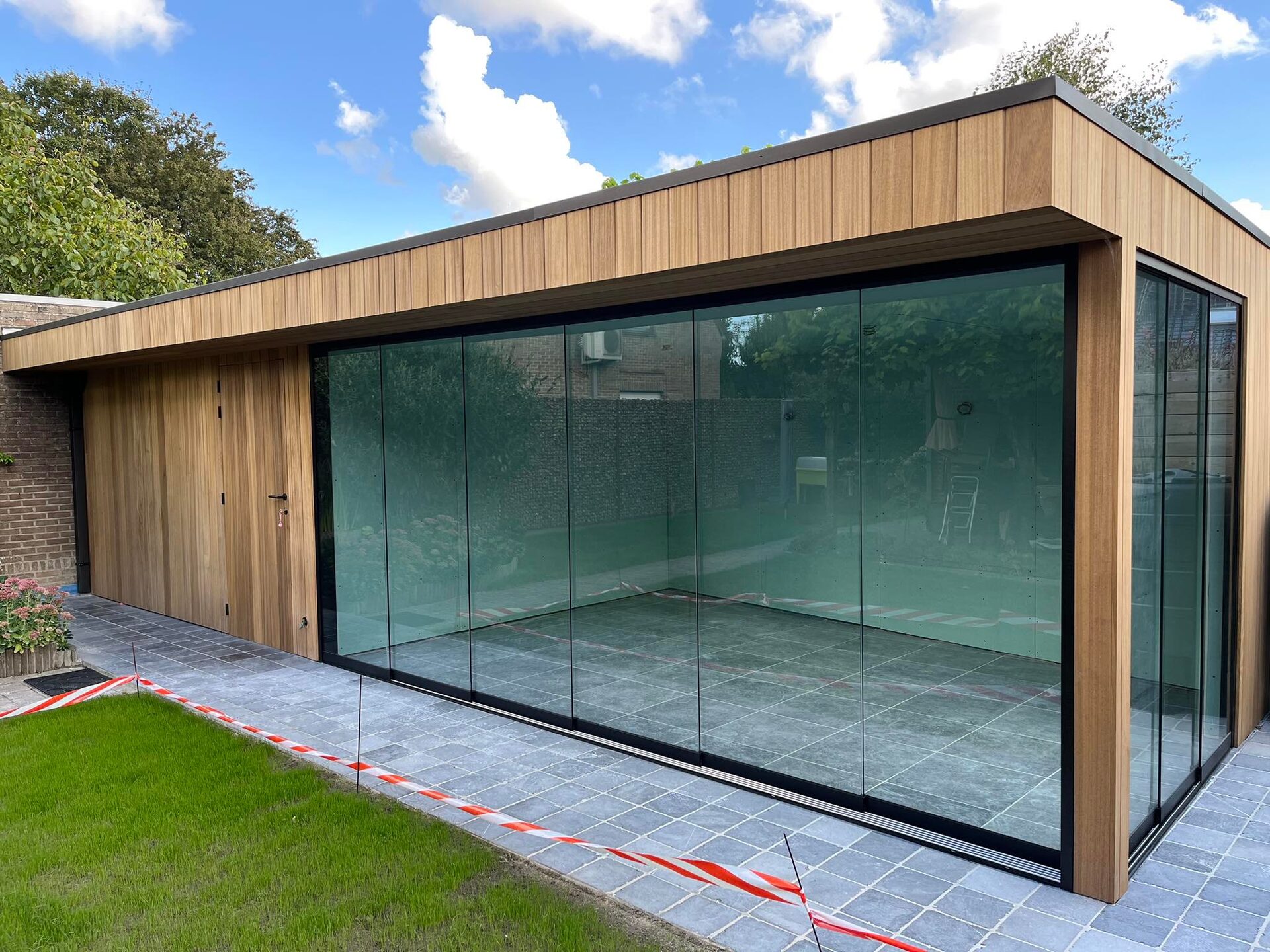 Houten poolhouse met glazen schuifwanden